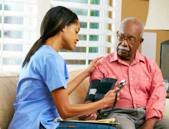 caregiver checks the vital signs of the old man